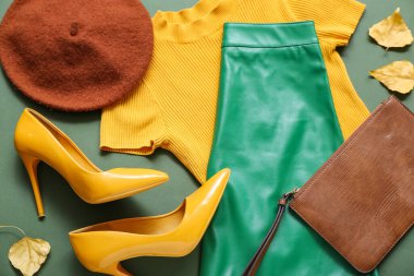 Renkli arka planda şık kadın kıyafetleri, aksesuarları ve sonbahar yapraklarıyla kompozisyon, yakın plan