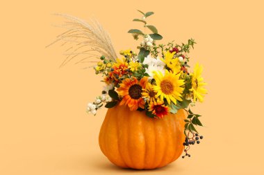 Sarı arka planda balkabağında güzel bir sonbahar buketi