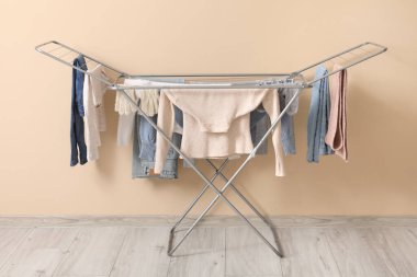 Kışlık giysileri olan kurutucu bej duvarın yanında.