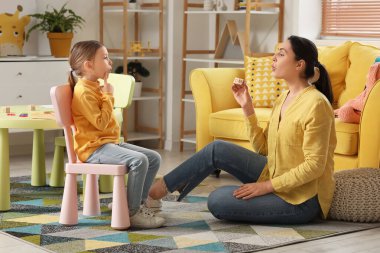 Ofiste mektupları telaffuz eden küçük tatlı bir kızı olan kadın konuşma terapisti.