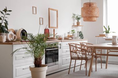 Yemek masası ve sandalyeleri olan modern mutfağın şık iç tasarımı.