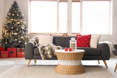 Gri kanepesi, Noel ağacı ve şenlikli süslemeleri olan oturma odasının içinde.