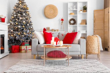 Oturma odasının içinde kanepe, raf ünitesi ve yanan mumlar var.