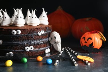 Siyah arka planda hayaletler, gözler, örümcekler ve şekerler olan lezzetli Cadılar Bayramı pastası.