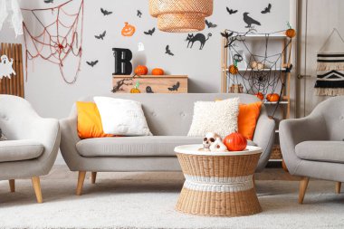 Cadılar Bayramı için kanepe ve balkabaklarıyla dekore edilmiş şık bir oturma odası.