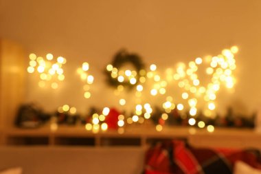 Çelenkli firavun dalları ve klozette parlayan çelenkler Noel için süslenmiş odada, bulanık bir görüntü.