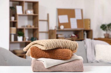 Oturma odasındaki masada şık kış bej kazakları yığını.