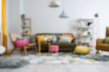 Koltuğu, koltuğu ve raf üniteleri olan şık oturma odasının bulanık görüntüsü