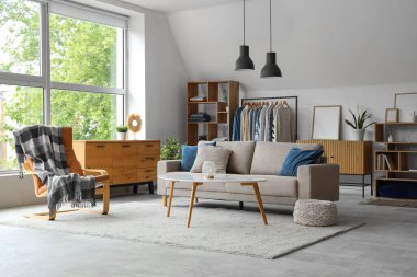 Elbise askısı, kanepe ve raf üniteleriyle oturma odasının içinde.