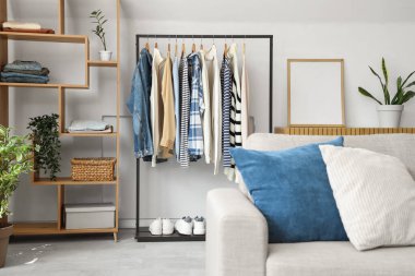 Elbise askısı ve raf ünitesi olan oturma odasının içinde.