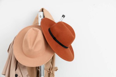 Fiyakalı keçeli şapkalarla aydınlık duvarın yanında askı, yakın plan.