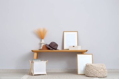 Şık şapkalı banklar, otlar ve aydınlık odada boş çerçeveler.