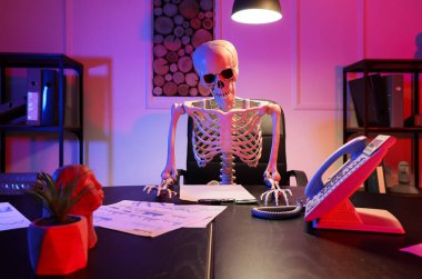 Geceleri ofiste oturan insan iskeleti modeli.