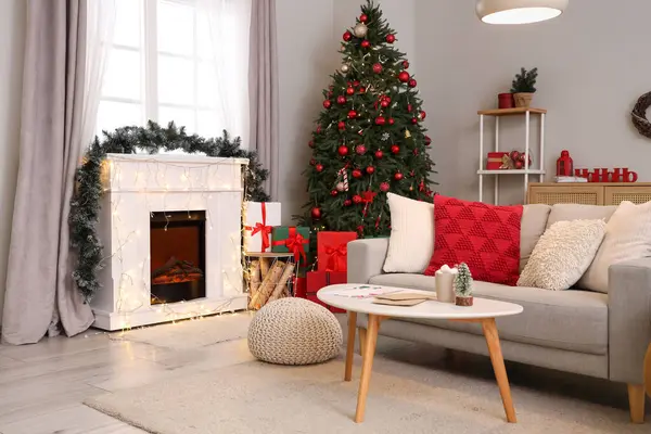 Oturma odasının içinde Noel ağacı, kanepe ve şömine var.