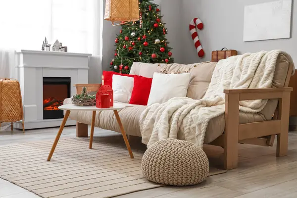 Beyaz kanepesi, sehpası, Noel ağacı ve şöminesi olan festival salonu.
