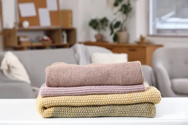 Oturma odasındaki masada şık bir kazak yığını.