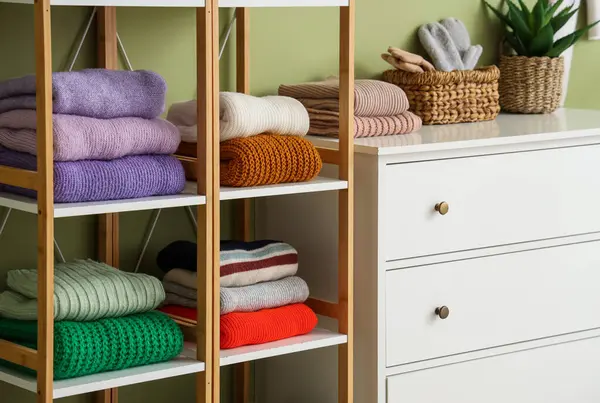 Çekmeceleri ve kışlık kıyafetleri olan modern soyunma odasının içinde.