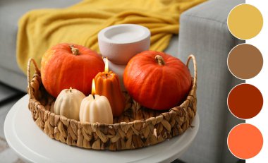 Evdeki taburede balkabağı şeklinde yanan mumlarla dolu hasır sepet, yakın plan.