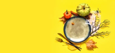 Sarı arkaplanda balkabakları ile Cadılar Bayramı masa ayarları metin için boşluk