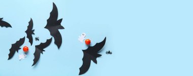 Cadılar Bayramı partisi için beyaz yarasalar, hayaletler ve balkabakları mavi arka planda metin için alan