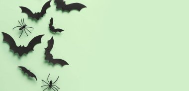 Cadılar Bayramı partisi için kağıt yarasalar ve örümcekler yeşil arka planda ve metin için yer var