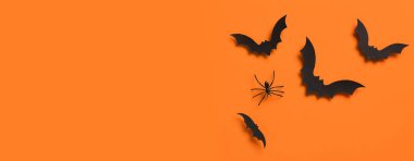 Turuncu arka planda Cadılar Bayramı partisi için kağıt yarasalar ve örümcek.