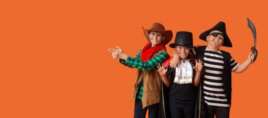 Cadılar Bayramı partisi için giyinmiş mutlu çocuklar turuncu arka planda ve mesaj için yer var.