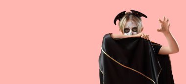 Cadılar Bayramı için giyinmiş küçük çocuk pembe arka planda, mesaj için yeri olan bir vampir.