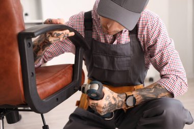 Matkap montaj koltuğu olan erkek işçi, yakın plan.