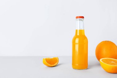 Beyaz arka planda bir şişe taze portakal suyu.