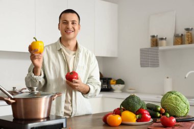 Mutfakta dolmalık biberli genç adam.