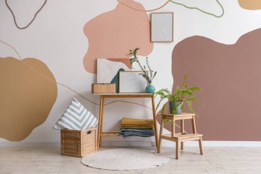 Çiçek, resim ve okaliptüs vazosu güzel bir odada, bankta duruyor.