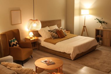 Rahat koltuğu, sehpası ve yatağı olan şık bir yatak odası.