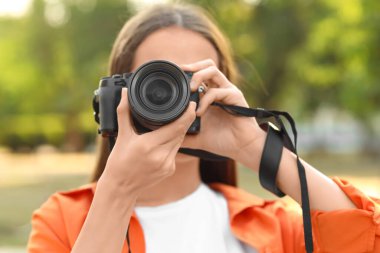 Park yerinde modern kameralı genç bayan fotoğrafçı.