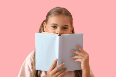 Pembe arka plan kitabı olan tatlı bir kız öğrenci.