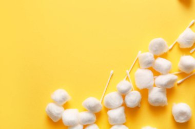 Sarı arka planda pamuk topları ve çubuklar