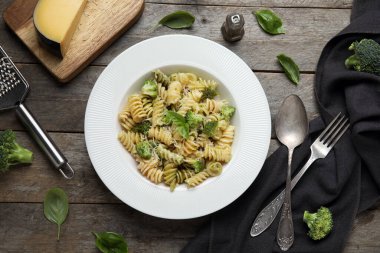 Tahta zemin üzerinde brokoli ve fesleğen yapraklı lezzetli fusilli makarna.