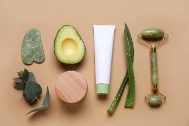 Renkli arka planda doğal kozmetik ürünleri, malzemeler ve yüz masajı araçlarıyla kompozisyon