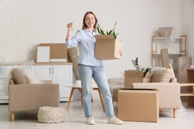 Taşındığı gün yeni daireden anahtarı olan genç bir kadın.