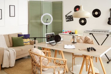 Podcaster 'ın atölyesinin içinde iş yeri, kanepe ve vinil diskler var.