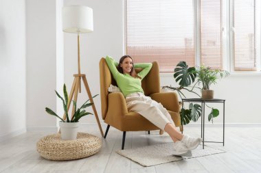 Evdeki rahat koltukta dinlenen güzel kadın.