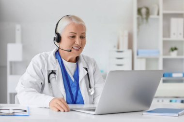 Bilgisayarlı kadın doktor hastanede online danışmanlık yapıyor.