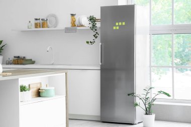 Modern buzdolabı, raf ve masa olan mutfağın içi.