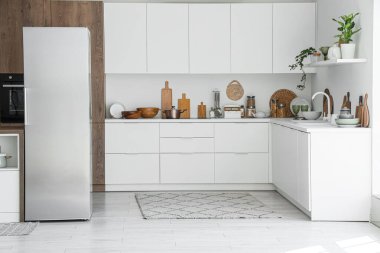 Buzdolabı ve tezgahları olan modern mutfağın içi.