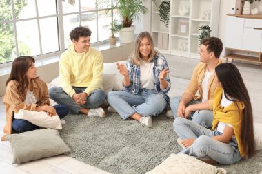 Grup terapisinde halıda konuşan genç bir kadın.