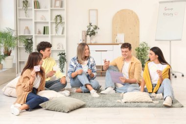 Grup terapi seansında kağıt tebessümleri olan gençler.