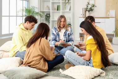 Grup terapi seansında not defterlerine yazan gençler