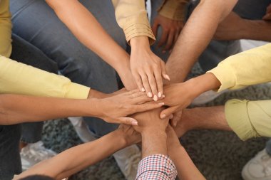 Gençler grup terapisi seansında el ele tutuşuyorlar.