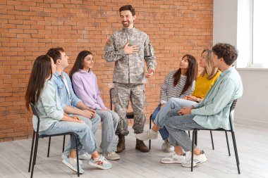 Grup terapi seansında insanların olduğu bir erkek asker.