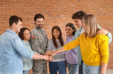 Grup terapi seansında el ele tutuşan gençler